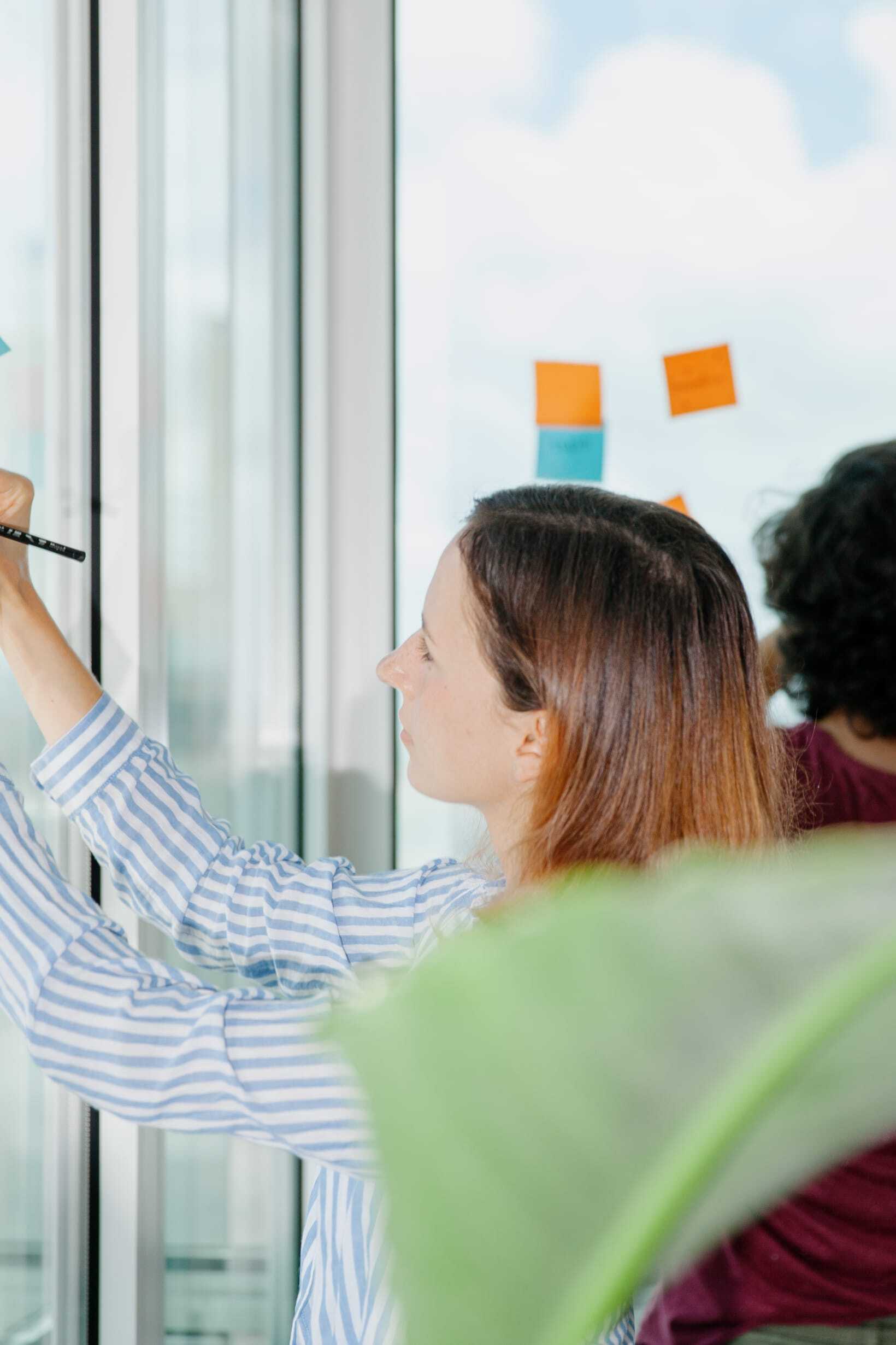 Person writing ideas on a glass wall